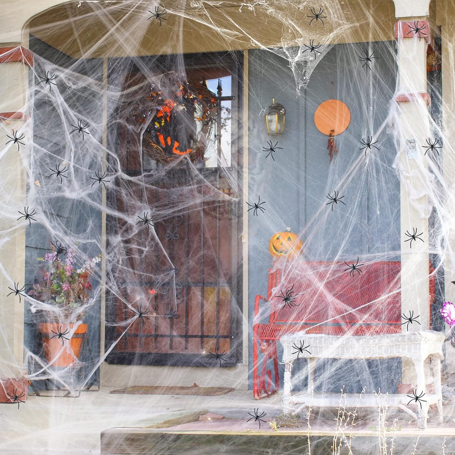 Halloween spider web decorations with 150 fake spiders covering a front porch — Amazon outdoor Halloween decor.